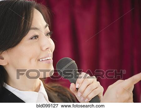 Japanese businesswoman talking into microphone View Large Photo Image Stock Photo - Japanese businesswoman talking into microphone. Fotosearch