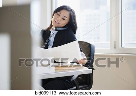 Stock Image - Japanese businesswoman talking on telephone. Fotosearch