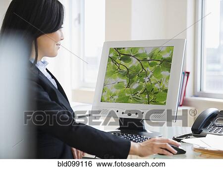 Stock Photograph - Japanese businesswoman using computer. Fotosearch