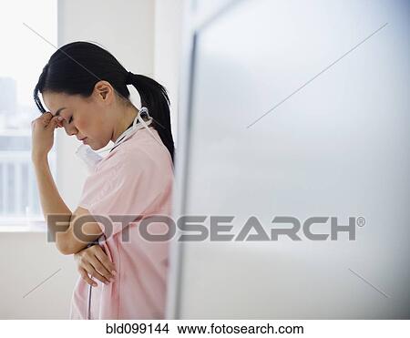 Picture - Japanese nurse with a headache. Fotosearch