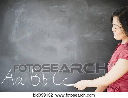 Stock Image - Japanese teacher writing on blackboard. Fotosearch