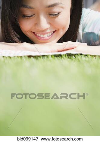 Stock Photo - Japanese woman laying in grass. Fotosearch