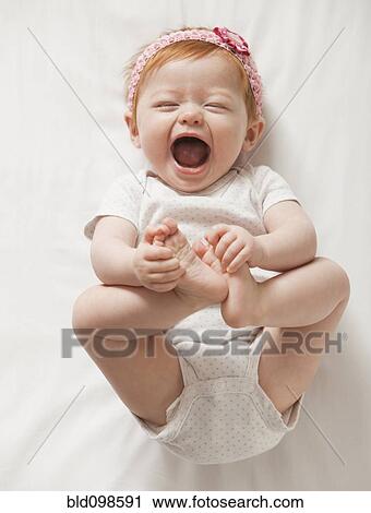 Stock Image - Laughing Caucasian baby girl. Fotosearch