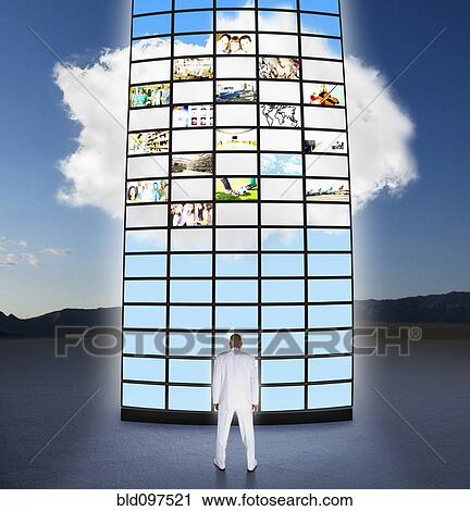 Mixed race businessman looking at towering monitors View Large Photo Image Stock Image - Mixed race businessman looking at towering monitors. Fotosearch