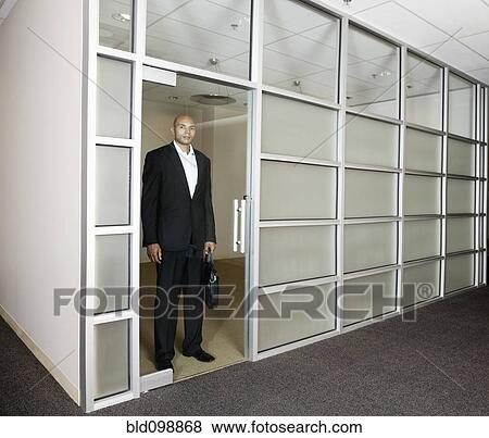 Mixed race businessman standing in office doorway View Large Photo Image Stock Photo - Mixed race businessman standing in office doorway. Fotosearch