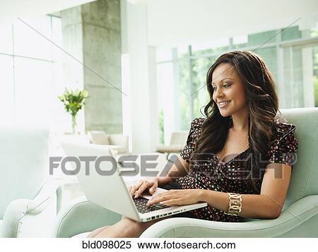 Mixed race businesswoman using laptop in lobby View Large Photo Image Stock Photography - Mixed race businesswoman using laptop in lobby. Fotosearch
