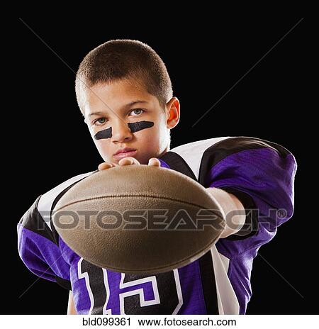 Stock Image - Mixed race football player holding football. Fotosearch