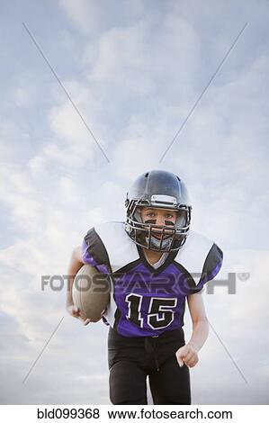 Mixed race football player running with football View Large Photo Image Stock Photo - Mixed race football player running with football. Fotosearch
