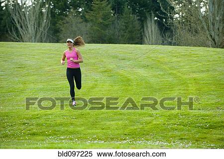 Mixed race runner jogging across field View Large Photo Image Stock Photography - Mixed race runner jogging across field. Fotosearch