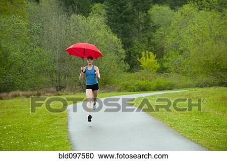 Mixed race runner training on remote road with umbrella View Large Photo Image Stock Image - Mixed race runner training on remote road with umbrella. Fotosearch