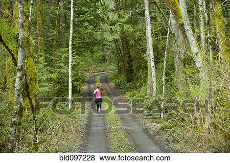 Stock Photo - Mixed race runner training on remote road. Fotosearch