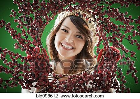 Mixed race woman holding berry wreath View Large Photo Image Stock Image - Mixed race woman holding berry wreath. Fotosearch
