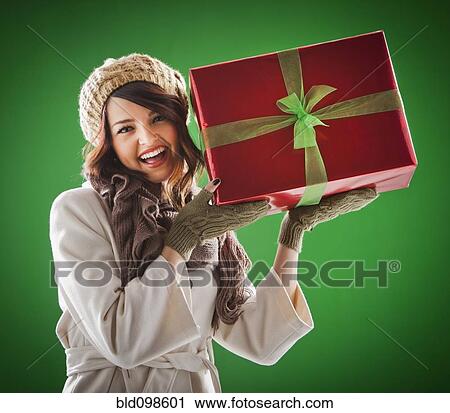 Mixed race woman holding Christmas gift View Large Photo Image Stock Image - Mixed race woman holding Christmas gift. Fotosearch