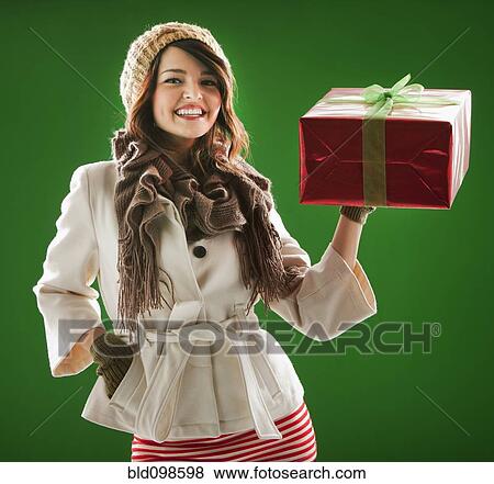 Stock Photo - Mixed race woman holding Christmas gift. Fotosearch