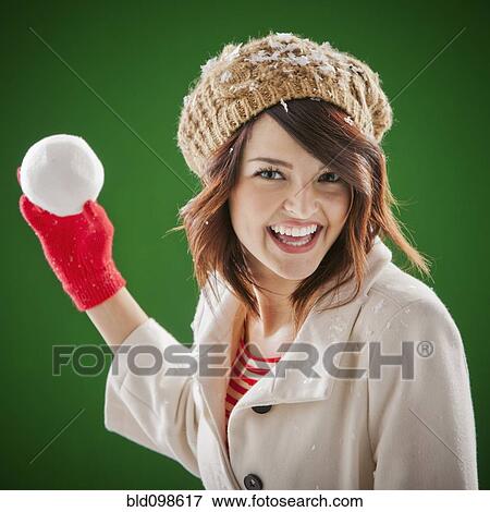 Stock Photo - Mixed race woman throwing snowball. Fotosearch