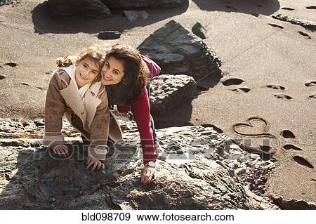 Stock Photo - Mother and daughter playing in beach. Fotosearch