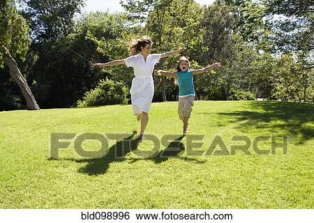 Mother and daughter running down hill in park View Large Photo Image Stock Photograph - Mother and daughter running down hill in park. Fotosearch
