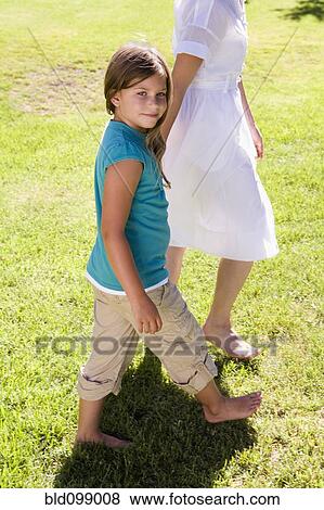 Stock Photo - Mother and daughter walking and holding hands. Fotosearch