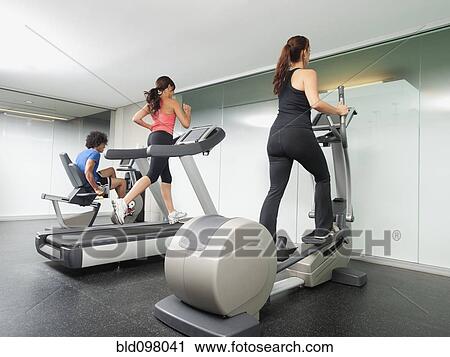 Stock Image - People using gym exercise equipment. Fotosearch