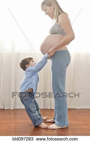 Pregnant Caucasian mother holding hands with son View Large Photo Image Stock Image - Pregnant Caucasian mother holding hands with son. Fotosearch
