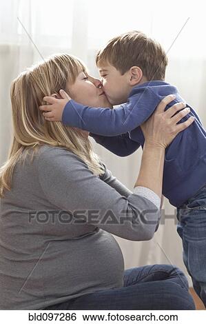 Pregnant Caucasian mother kissing son View Large Photo Image Stock Photograph - Pregnant Caucasian mother kissing son. Fotosearch