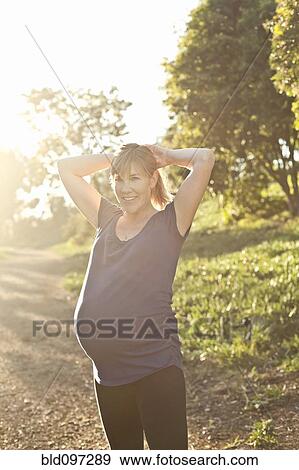 Stock Photo - Pregnant Caucasian woman exercising outdoors. Fotosearch