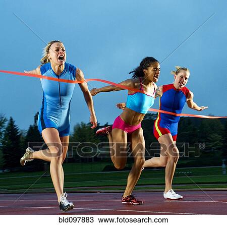 Stock Image - Runners crossing finish line in race. Fotosearch