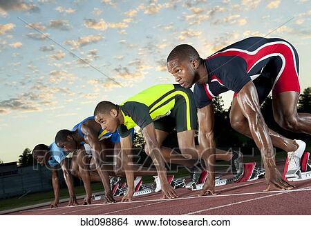 Runners preparing for race at starting blocks View Large Photo Image Picture - Runners preparing for race at starting blocks. Fotosearch