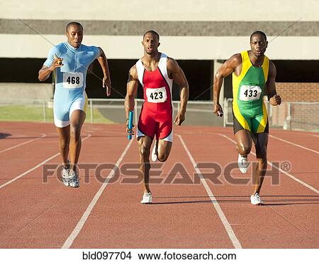 Picture - Runners running on track in relay race. Fotosearch
