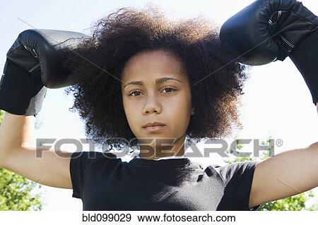 Stock Photo - Serious teenage girl wearing boxing gloves. Fotosearch