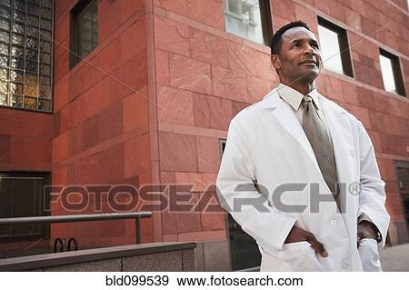 Stock Photo - Smiling African American doctor standing outdoors. Fotosearch