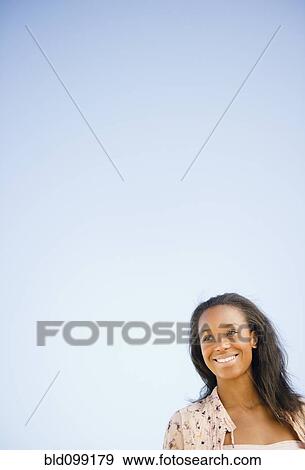 Smiling Black woman standing outdoors View Large Photo Image Stock Photo - Smiling Black woman standing outdoors. Fotosearch