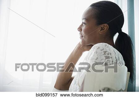 Stock Photo - Smiling Black woman thinking. Fotosearch