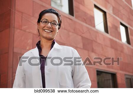 Stock Photo - Smiling doctor standing outdoors. Fotosearch