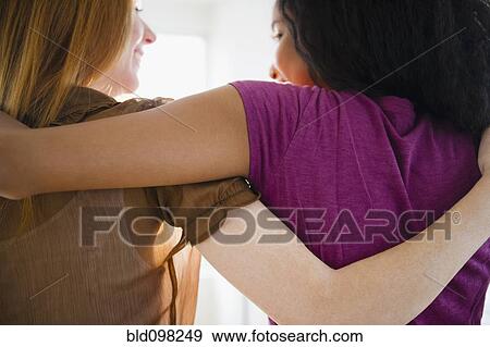 Stock Photo - Smiling friends hugging. Fotosearch