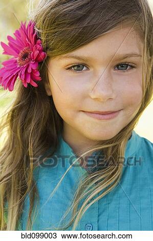 Stock Image - Smiling girl with flower in her hair. Fotosearch