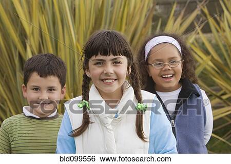 Stock Photograph - Smiling Hispanic children standing outdoors. Fotosearch