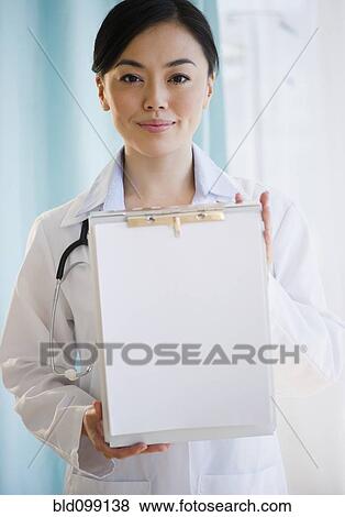 Stock Photo - Smiling Japanese doctor holding medical record. Fotosearch