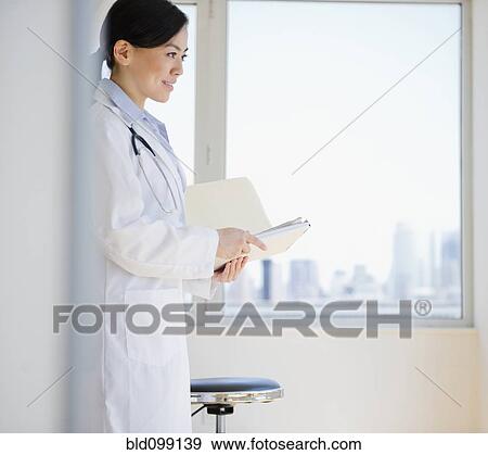 Stock Photo - Smiling Japanese doctor holding medical record. Fotosearch