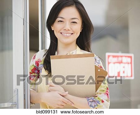 Smiling Japanese woman holding notepad View Large Photo Image Stock Image - Smiling Japanese woman holding notepad. Fotosearch