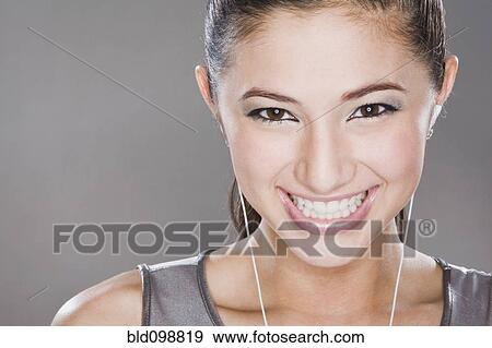 Smiling mixed race woman listening to headphones View Large Photo Image Stock Photo - Smiling mixed race woman listening to headphones. Fotosearch