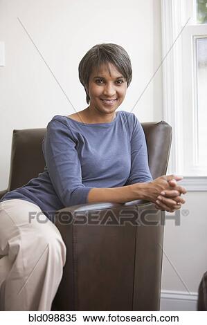 Stock Photography - Smiling Native American woman sitting in chair. Fotosearch