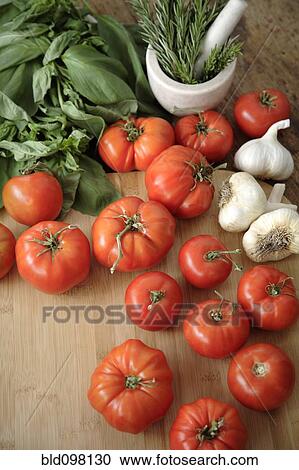 Tomatoes, garlic and basil on cutting board View Large Photo Image Stock Image - Tomatoes, garlic and basil on cutting board. Fotosearch