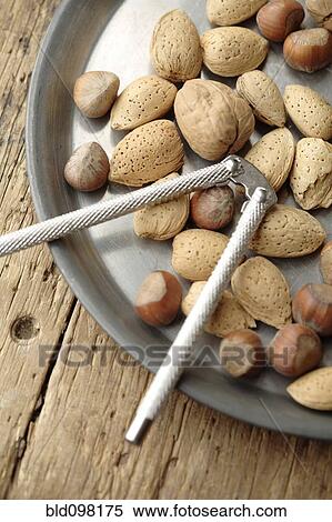 Stock Photography - Variety of nuts and nutcracker on platter. Fotosearch