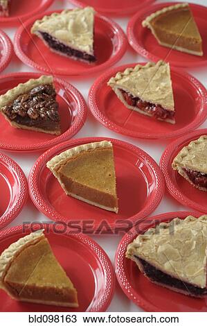 Stock Image - Variety of slices of pie on plates. Fotosearch