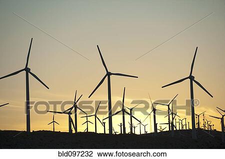 Stock Image - Wind farm in desert at sunset. Fotosearch