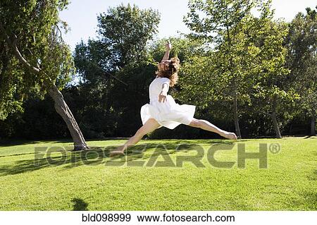 Stock Photo - Woman dancing in park. Fotosearch