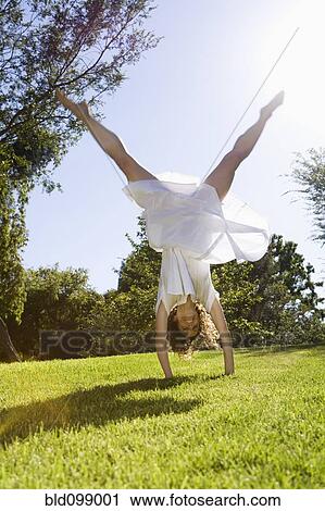 Woman doing cartwheel in park View Large Photo Image Stock Image - Woman doing cartwheel in park. Fotosearch