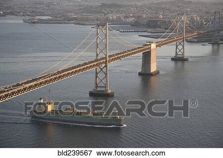 Stock Photo - Aerial view of freighter under urban bridge. Fotosearch