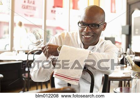 Stock Photo - African American waiter sitting in restaurant. Fotosearch